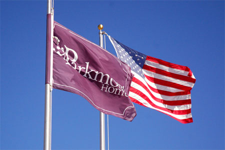 Custom Parkmont Homes flag flying with the U.S. flag