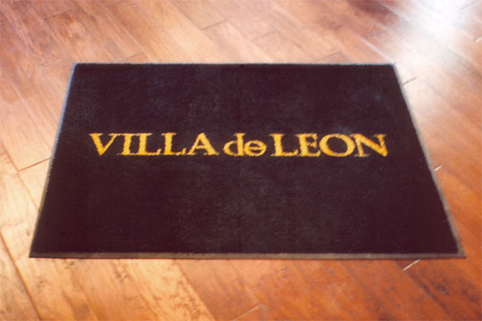 Custom rug with the Villa De Leon logo printed on it