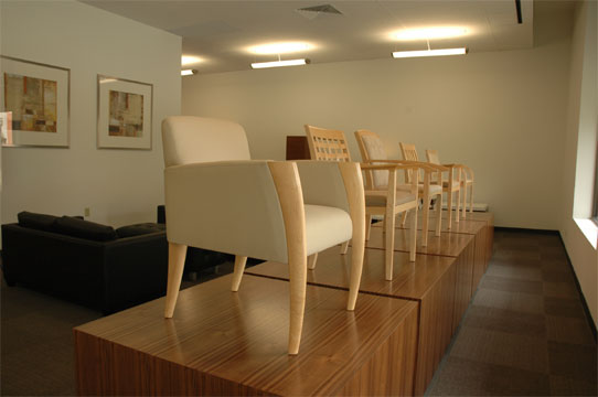 A line of guest chairs on pedestals at the entrance of the Novikoff Furniture showroom