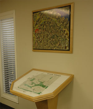 A light wood site map table that extends fromthe wall at an angle