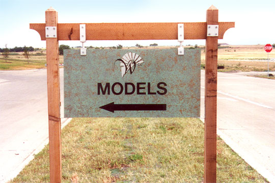 A hanging sign at Windmill Farms with an arrow pointing to the left
